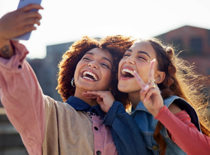 Two female friends smiling for the camera after a visit with their Aetna dentist in Granger