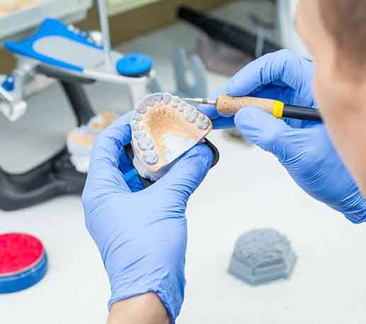 Lab technician carving dentures